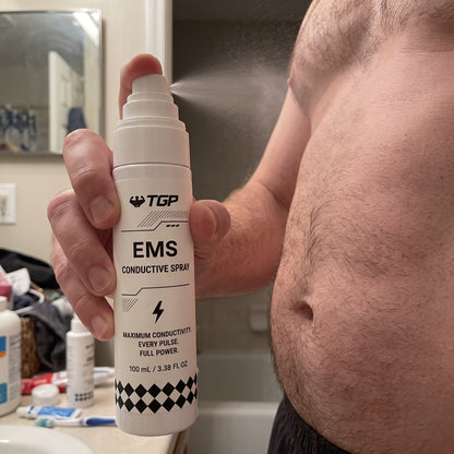 Misting the EMS Conductive Spray onto clean, dry skin