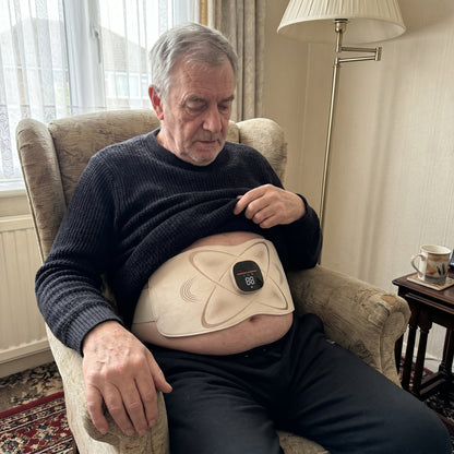 Man relaxing in an armchair wearing the Power Belt Pro